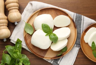 Lezzetli mozarella peyniri parçaları, fesleğen yaprakları ve sallanan ahşap masa, düz yatıyordu.