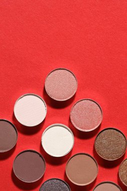 Kırmızı arka planda güzel göz farı dolgu kapları, düz yatış. Metin için boşluk