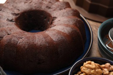 Lezzetli çikolatalı kek ve cevizler masada, yakın plan.