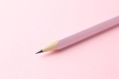 Pembe arka planda bir grafit kalem, yakın plan.