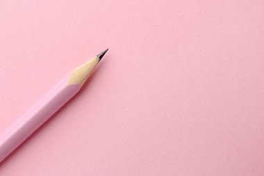 Pembe arka planda bir grafit kalem, üst manzara. Metin için boşluk