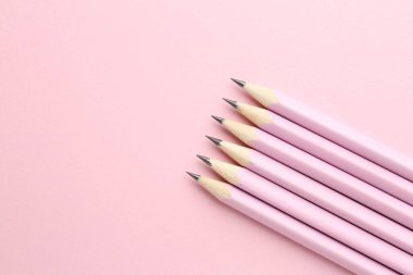 Pembe arka planda bir sürü grafit kalem var. Metin için boşluk