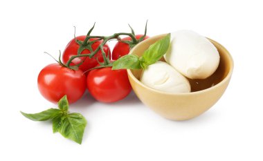 Beyaz arka planda lezzetli mozzarella peynir topları, domates ve fesleğen.