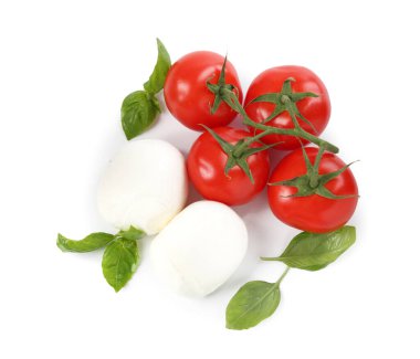 Beyaz arka planda lezzetli mozzarella peynir topları, domates ve fesleğen.