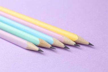 Menekşe arkaplan üzerinde birçok grafit kalem, yakın plan