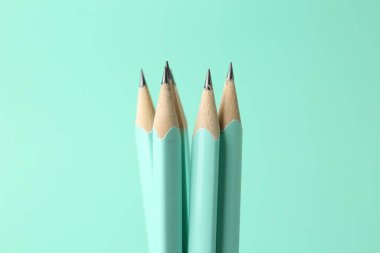 Turkuaz arka planda birçok grafit kalem, yakın plan