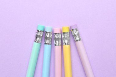 Menekşe arkaplanda silgisi olan bir sürü grafit kalem. Metin için boşluk