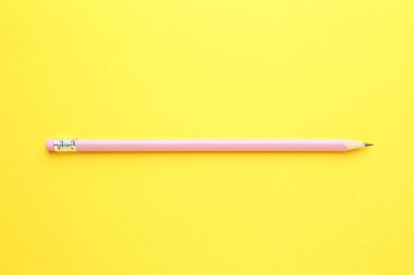 Sarı arkaplanda silgisi olan bir grafit kalem, üst görünüm.