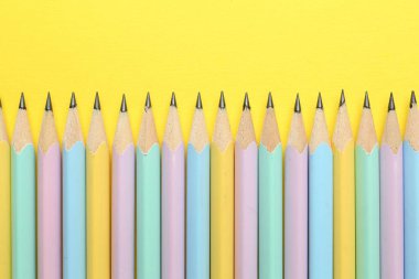 Sarı arka planda bir sürü grafit kalem var. Metin için boşluk