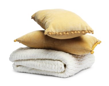 Katlanmış yün battaniye ve beyaz yastıklar.