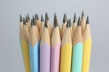 Açık gri arkaplanda birçok grafit kalem, yakın plan