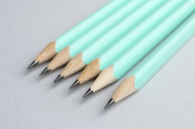 Açık gri arkaplanda birçok grafit kalem, yakın plan