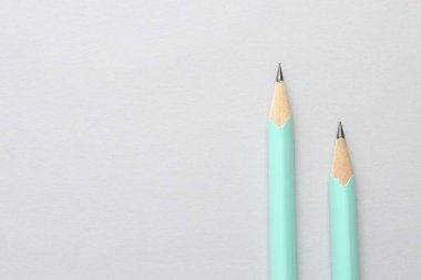 Açık gri zemin üzerinde iki grafit kalem, düz zemin. Metin için boşluk