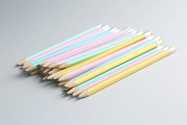 Açık gri arkaplanda birçok grafit kalem, yakın plan