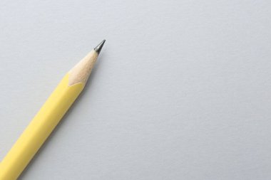 Açık gri arka planda bir grafit kalem, üst manzara. Metin için boşluk