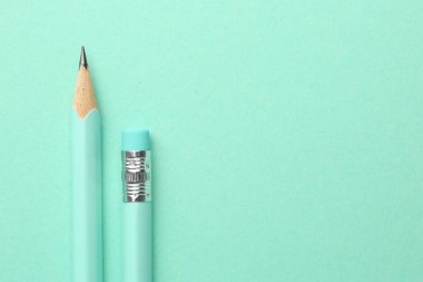 Turkuaz arka planda iki grafit kalem, üst manzara. Metin için boşluk