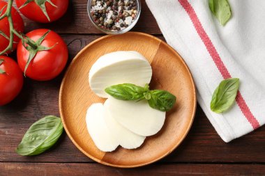 Lezzetli mozzarella, domates ve fesleğen, ahşap masa, düz uzanma