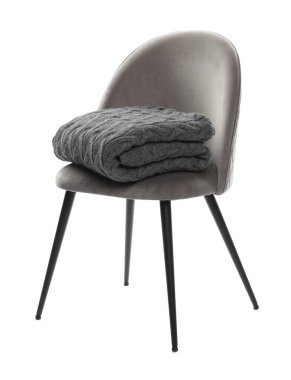 Beyaz üzerinde battaniyesi olan rahat bir koltuk.