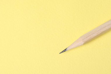 Sarı arka planda bir grafit kalem, en üstte. Metin için boşluk