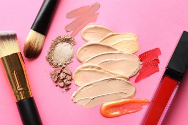 Eflatun arka planda farklı kozmetik ürünler ve makyaj fırçaları, düz yatış