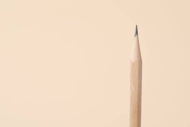 Bej arka planda bir grafit kalem, yakın plan. Metin için boşluk