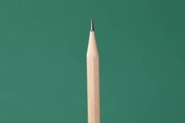 Yeşil arkaplanda bir grafit kalem, yakın plan.