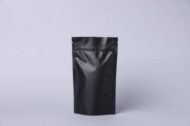 Açık gri arka planda fermuarlı bir stand-up kesesi. Tasarım için model