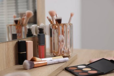 Farklı makyaj ürünleri ve kapalı mekandaki gösteriş fırçaları, yakın çekim
