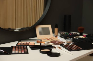 Tuvalet masasında farklı makyaj ürünleri ve fırçalar.