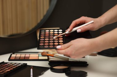 Makyaj masasında fırça ve göz falı olan kadın, yakın plan.