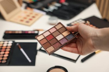 Makyaj masasında göz farı paleti olan kadın, yakın plan.