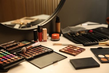 Tuvalet masasında farklı makyaj ürünleri ve fırçalar var.