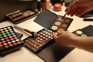 Makyaj masasında fırça ve göz falı olan kadın, yakın plan.