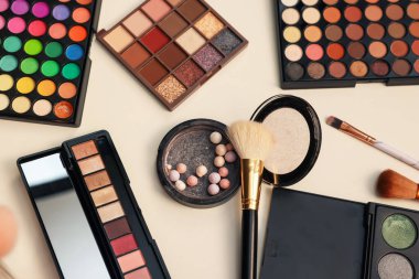 Makyaj malzemeleri ve fırçalar tuvalet masasında, düz yerde.