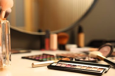 Tuvalet masasında farklı makyaj ürünleri ve fırçalar var.