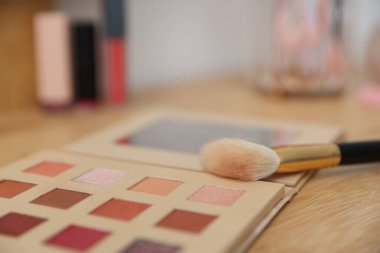 İçerideki ahşap tuvalet masasında fırçalı göz falı, yakın plan. Kozmetik ürünleri