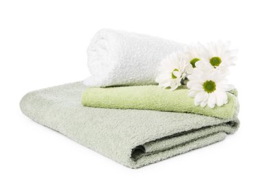 Yumuşak havlular ve beyaza izole edilmiş kasımpatı çiçekleri.