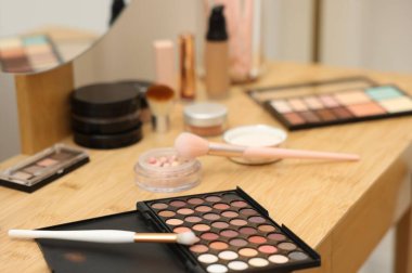 Farklı makyaj ürünleri ve kapalı mekandaki gösteriş fırçaları, yakın çekim