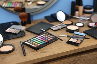 Kapalı alanda, ahşap masada farklı makyaj ürünleri.