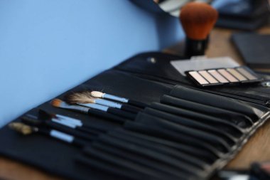 Makyaj fırçaları ve ürünler kapalı masa üzerinde, yakın plan. Metin için boşluk