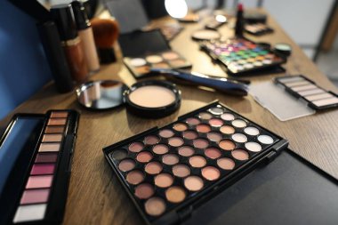 Kapalı alanda, ahşap masada farklı makyaj ürünleri.