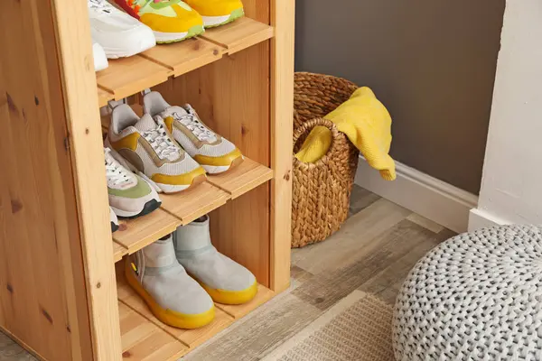 Girişteki raflarda farklı ayakkabılar, yakın plan. Ayakkabı deposu