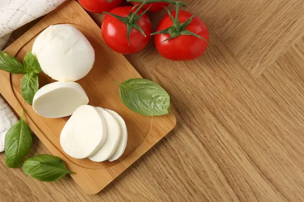 Lezzetli mozzarella, domates ve fesleğen, ahşap masa, düz yatak. Metin için boşluk