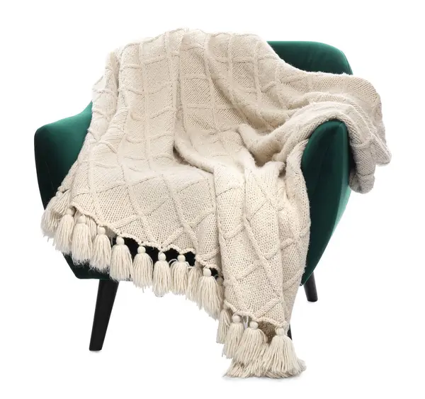 Beyaz üzerinde battaniyesi olan rahat bir koltuk.