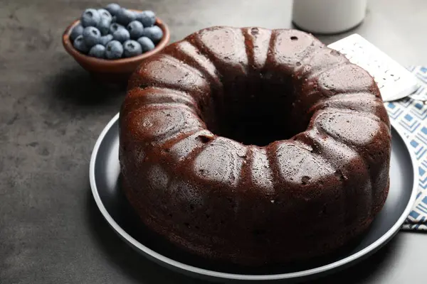 Lezzetli çikolatalı kek ve yaban mersini gri masada, yakın plan.