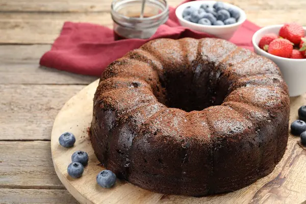 Ahşap masada yaban mersinli lezzetli çikolatalı kek, yakın plan.