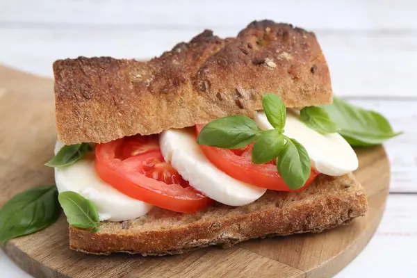 Mozarella peynirli, domatesli, fesleğenli, beyaz ahşap masa, yakın plan.