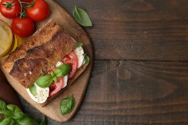 Peynirli, domatesli, ahşap masadaki fesleğenli lezzetli sandviç. Metin için boşluk