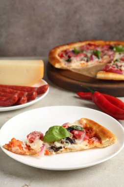 Hafif masada servis edilen ince tütsülenmiş sosisli, lezzetli bir pizza.