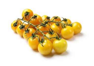 Beyaz üzerinde sarı kiraz domatesli dallar.